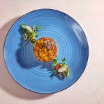 Zdjęcie jedzenia przedstawiające tatara z łososia na ryżu w formie krążka. fotografia kulinarna